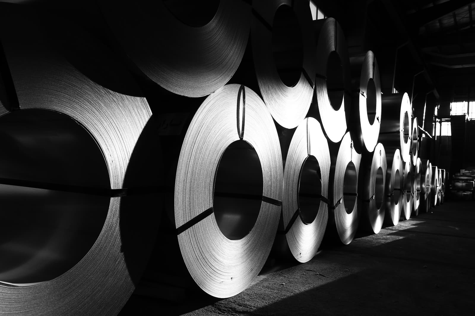 Coils of rolled steel stacked in a mill warehouse